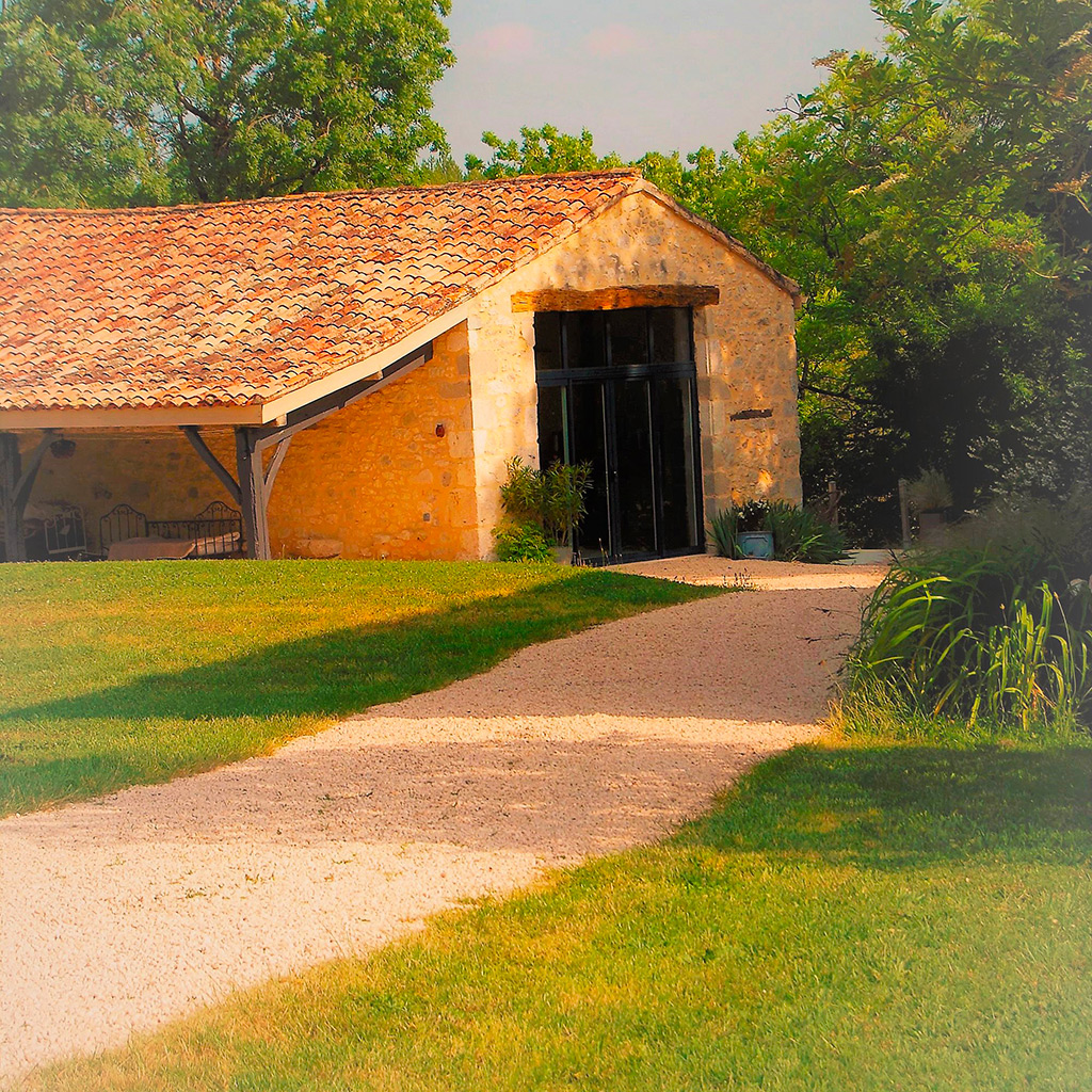 gite la feuillade exterieur bâtisse maison allée galet et herbe nature Location gîte la Feuillade aux oiseaux à Laussou - Villeréal