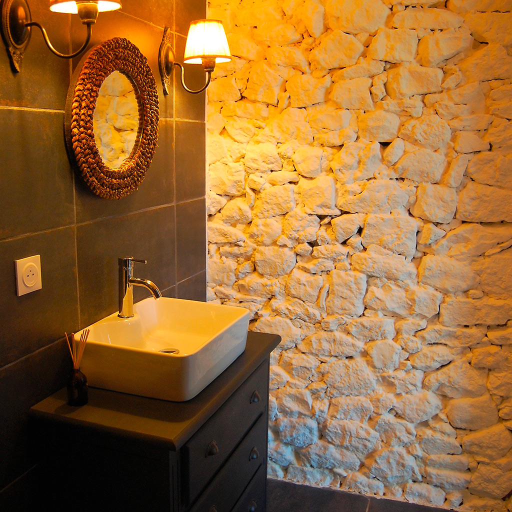 salle de bain pierre apparente grand carrelage noir vasque et applique retro charme Location gîte la Feuillade aux oiseaux à Laussou - Villeréal