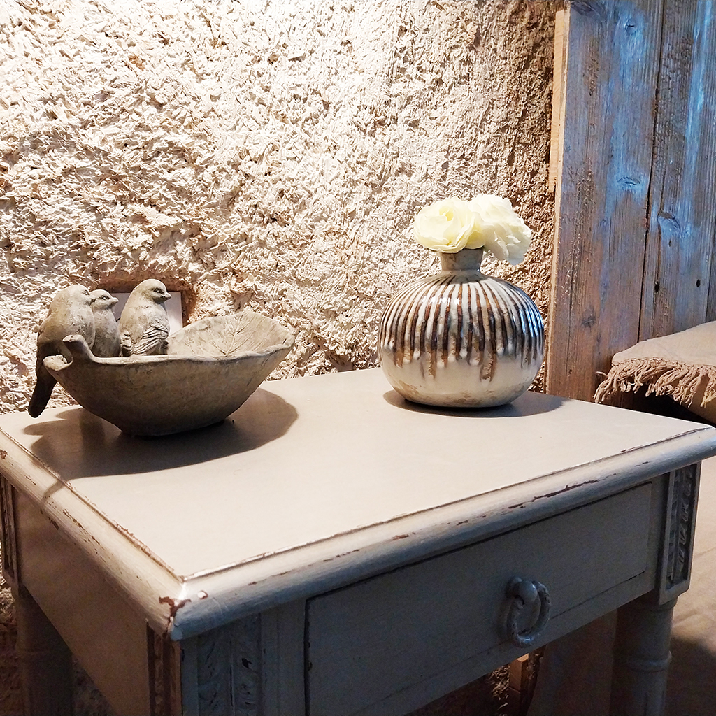 table de chevet chambre mur en pierre décoration oiseaux et bonbonne Location gîte la Feuillade aux oiseaux à Laussou - Villeréal