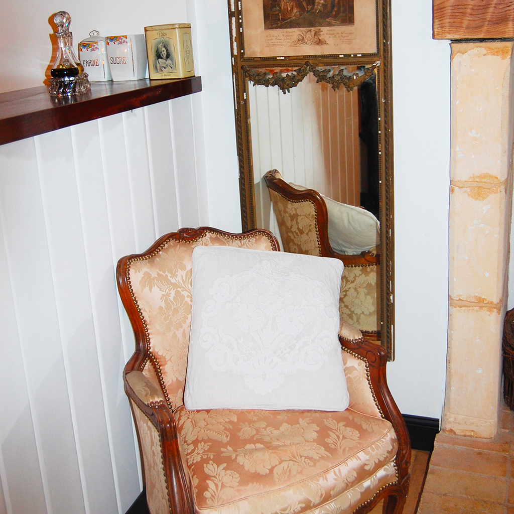 fauteuil voltaire ancien miroir encadré avec estampes au dessus devant bar de cuisine décoration ancienne vintage chic et charme